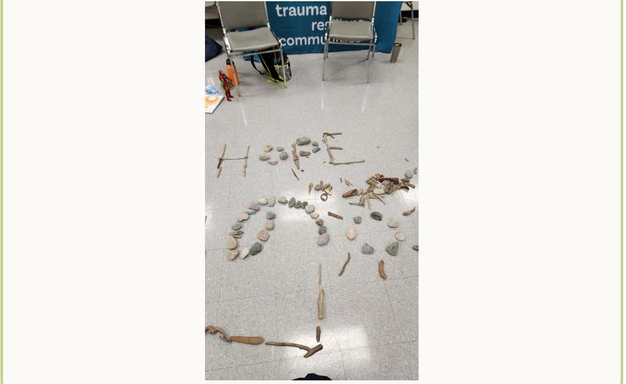 Word HOPE spelled out in driftwood and stones on the floor